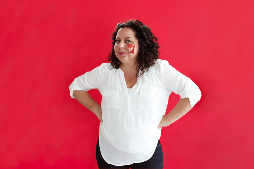 Candace D'agnolo standing in front of a bright red wall