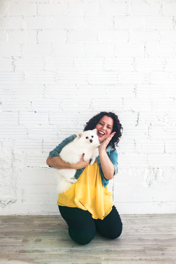 Founder of Pet Boss Nation kneeling and holding a dog
