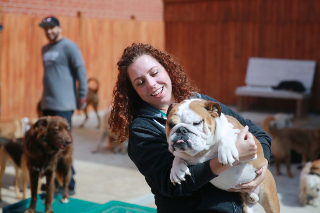 Pet Boss Nation pet business coach Candace D'Agnolo holding a bulldog at doggie daycare